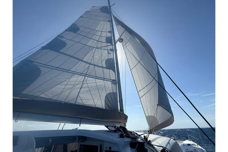 Slide: The Image of Sailing on a 2022 Outremer 51 catamaran with full sails against a clear blue sky. - 3
