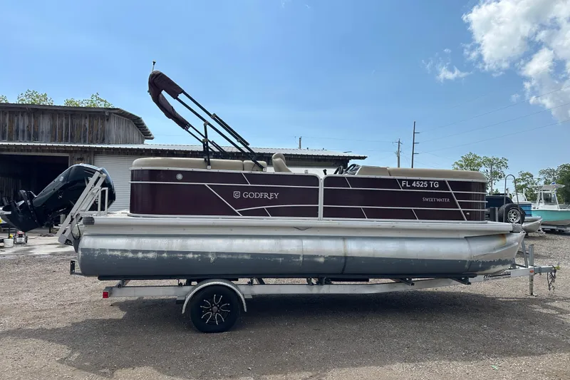 Slide: The Image of 2022 Godfrey Sweetwater 2286 SB pontoon boat on trailer, parked outdoors. - 7