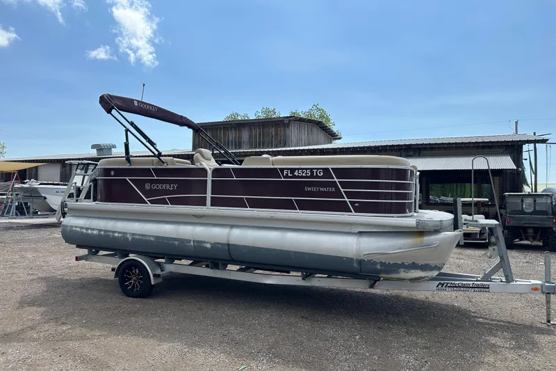 Slide: The Image of 2022 Godfrey Sweetwater 2286 SB pontoon boat on trailer, parked outdoors. - 8