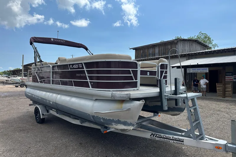 Slide: The Image of 2022 Godfrey Sweetwater 2286 SB pontoon boat on trailer, parked outdoors. - 9