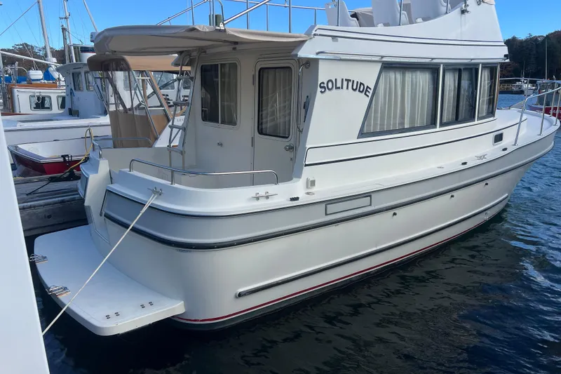 The Image of 2005 Camano Trawler boat named "Solitude" docked at a marina. - 0