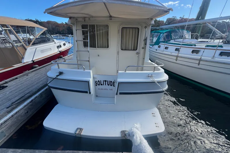 Slide: The Image of 2005 Camano Trawler "Solitude" docked in a marina, rear view. - 2