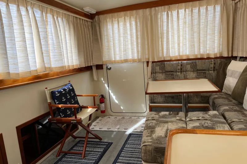 Slide: The Image of Interior of 2005 Camano Trawler with cozy seating, table, and nautical-themed decor. - 29