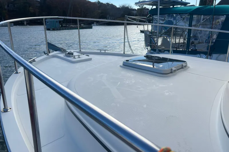 Slide: The Image of 2005 Camano Trawler boat deck with railing, docked by the water. - 3