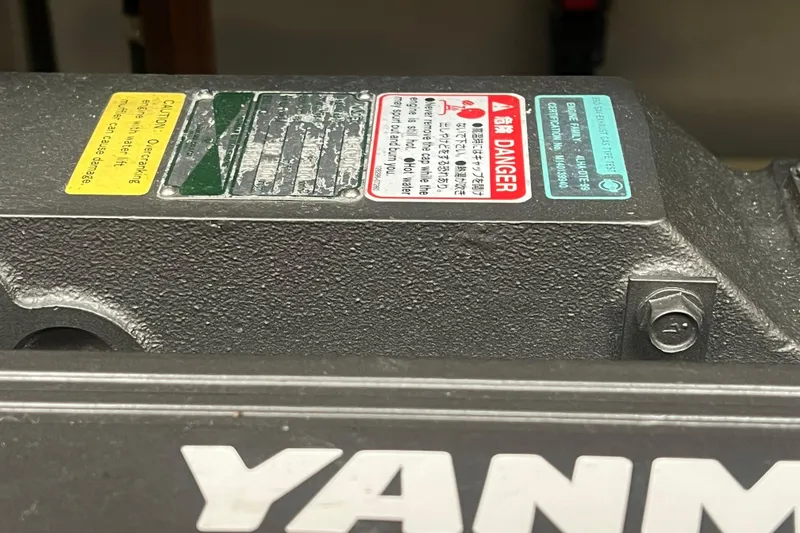 Slide: The Image of Close-up of a Yanmar engine with caution labels on a 2005 Camano Trawler. - 32