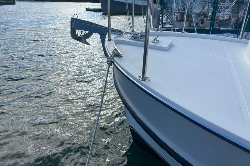 Slide: The Image of 2005 Camano Trawler boat anchored on calm water, showcasing its sleek design. - 4