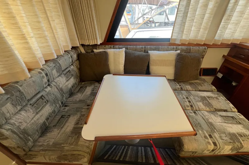 Slide: The Image of 2005 Camano Trawler interior with cushioned seating and a central table. - 8