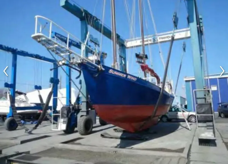 Slide: The Image of 1979 Colvin Gazelle boat in dry dock, painted blue and red. - 17