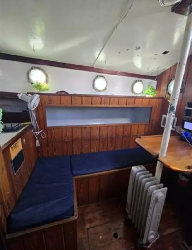 Slide: The Image of Interior of a 1979 Colvin Gazelle boat with wood paneling and seating area. - 7