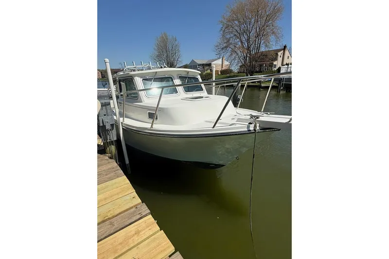 The Image of 2019 Parker 2150 boat docked on calm water under clear blue sky. - 0
