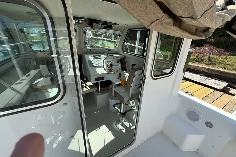 Slide: The Image of Interior view of a 2019 Parker 2150 boat, showcasing the helm and seating area. - 11