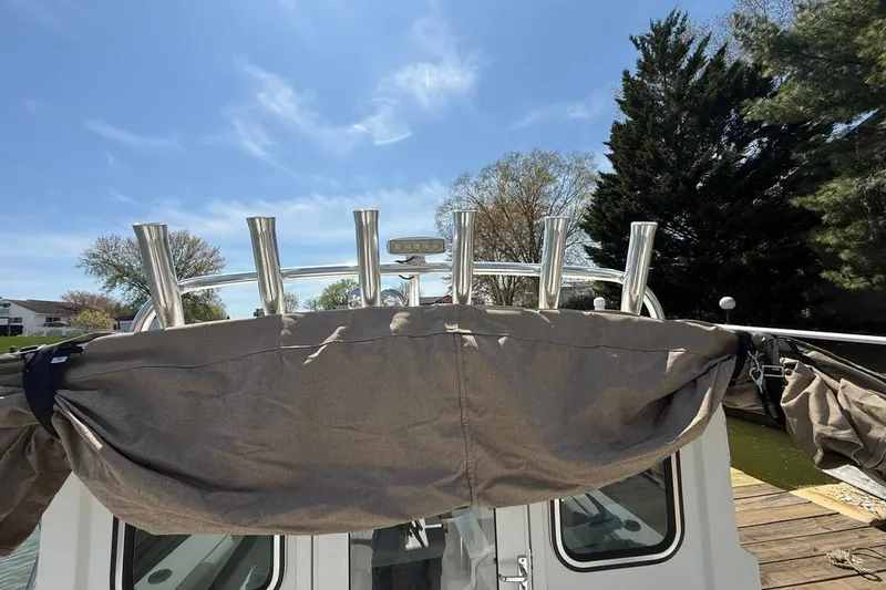 Slide: The Image of 2019 Parker 2150 boat with rod holders, docked under a clear blue sky. - 14