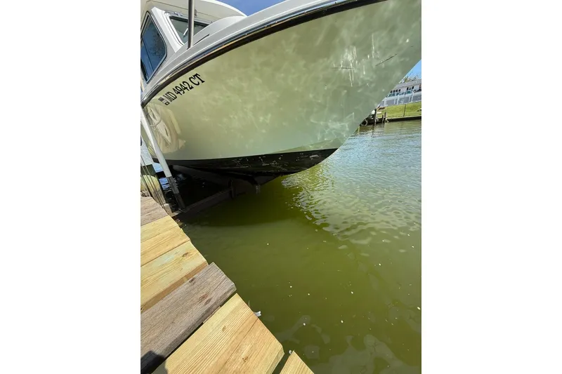 Slide: The Image of 2019 Parker 2150 boat docked on calm water near wooden pier. - 16