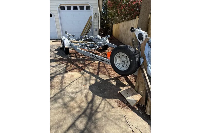 Slide: The Image of Boat trailer parked in driveway, near garage, for Parker 2150, 2019 model. - 17