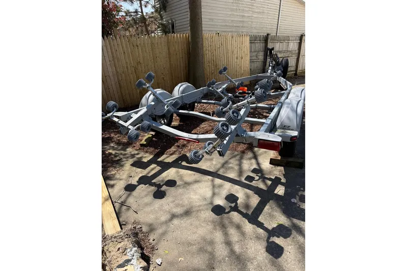 Slide: The Image of Boat trailer parked outdoors, Parker 2150 model, 2019, with adjustable rollers and sturdy frame. - 18