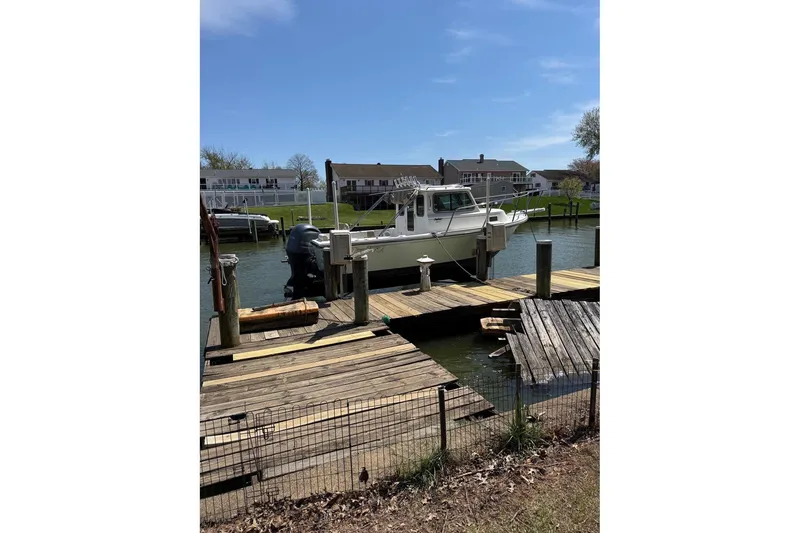 Slide: The Image of 2019 Parker 2150 boat docked at a wooden pier on a sunny day. - 5