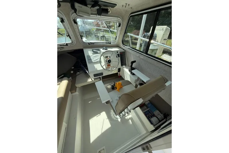 Slide: The Image of Interior of a 2019 Parker 2150 boat, featuring steering wheel and control panel. - 8
