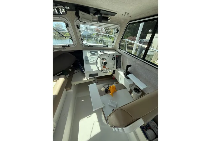 Slide: The Image of Interior of a 2019 Parker 2150 boat, featuring steering wheel and navigation equipment. - 9