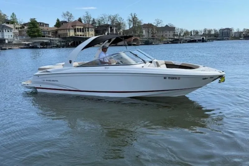 The Image of 2014 Regal 2700 ES Bowrider on a serene lake with waterfront homes in the background. - 1