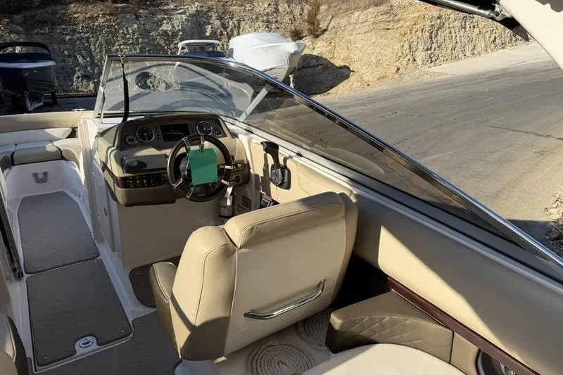 Slide: The Image of Interior view of a 2014 Regal 2700 ES Bowrider boat with beige seating and dashboard. - 16