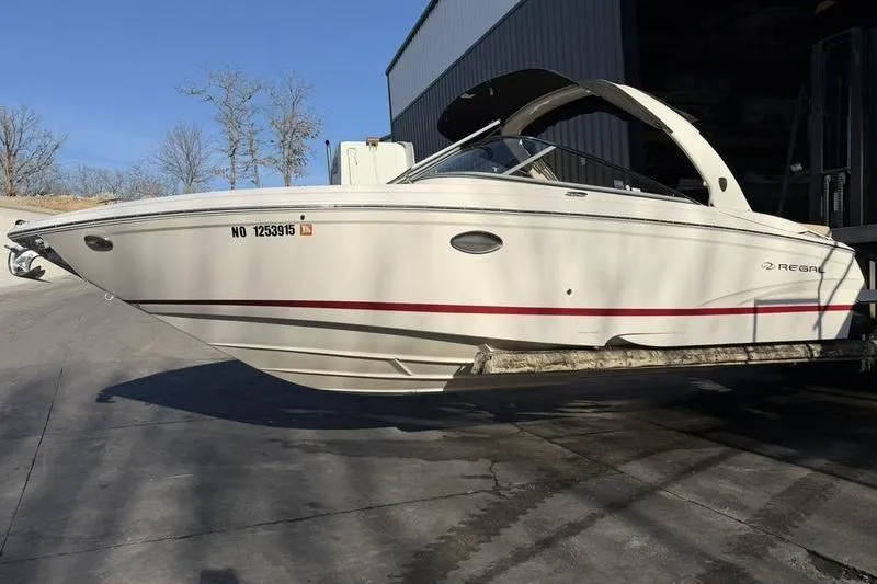 Slide: The Image of 2014 Regal 2700 ES Bowrider boat on a trailer, parked outdoors. - 3