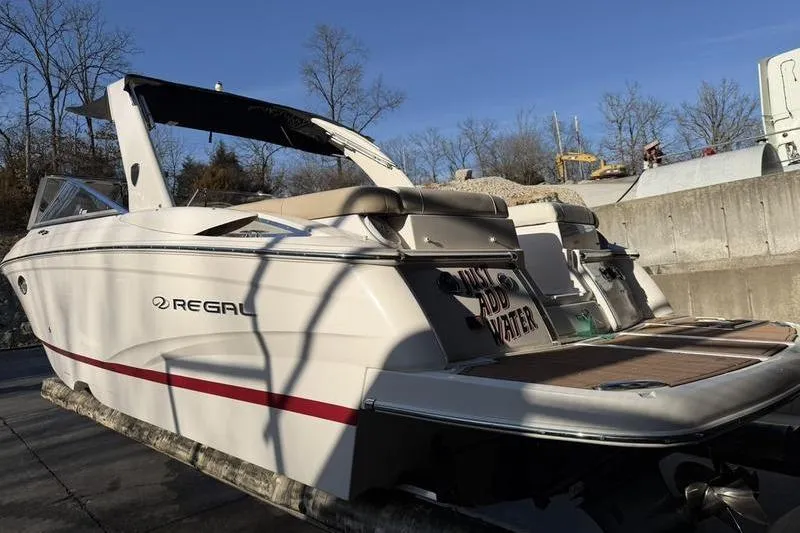 Slide: The Image of 2014 Regal 2700 ES Bowrider boat docked, featuring sleek design and spacious deck. - 5