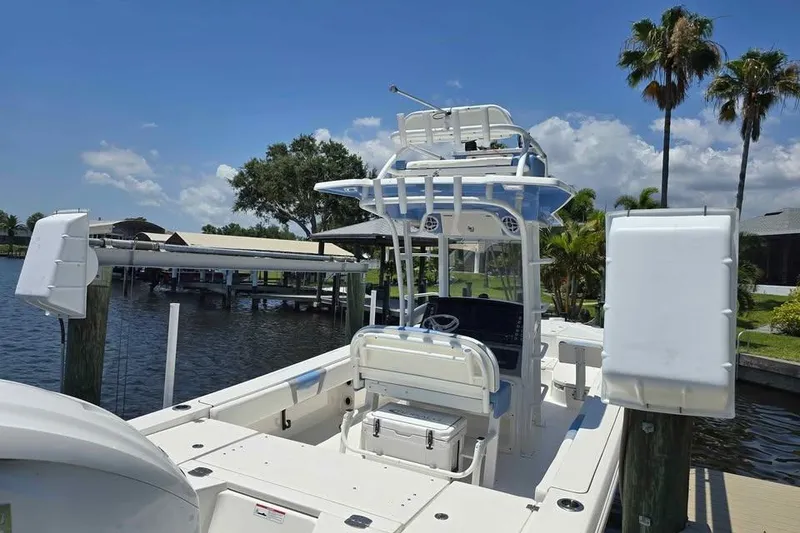 Slide: The Image of 2023 Robalo 266 Cayman SD boat docked by a scenic waterfront with palm trees. - 6