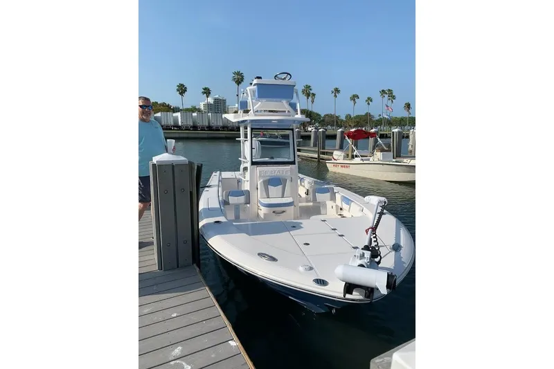 Slide: The Image of 2023 Robalo 266 Cayman SD boat docked at marina with palm trees in background. - 9