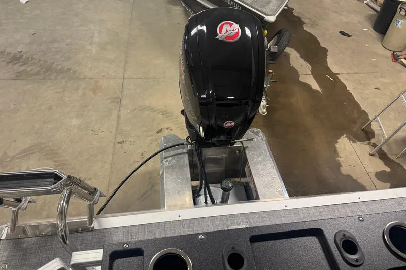 Slide: The Image of 2026 Sun Tracker Fishin' Barge 20 DLX with outboard motor in a garage setting. - 14