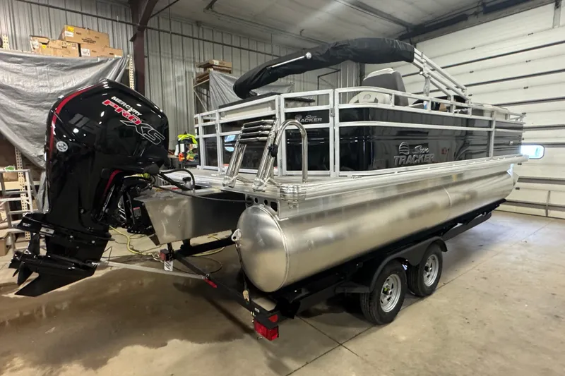 Slide: The Image of 2026 Sun Tracker Fishin' Barge 20 DLX pontoon boat in a garage setting. - 3