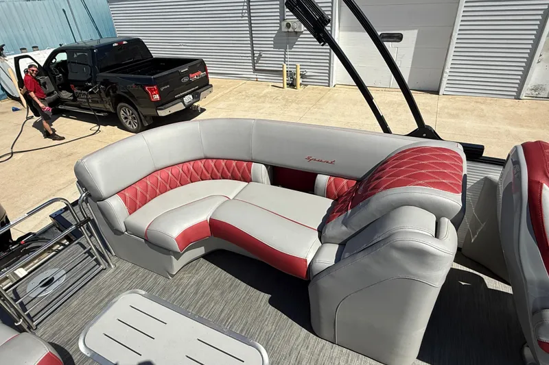 Slide: The Image of 2022 Bennington R 24 Quad Bench Bowrider with luxurious red and gray seating. - 18