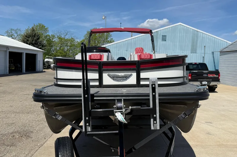 Slide: The Image of 2022 Bennington R 24 Quad Bench Bowrider on trailer, parked outdoors. - 2