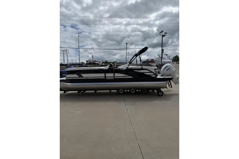 Slide: The Image of 2025 Bennington 26 MFB-SPT pontoon boat on trailer under cloudy sky. - 7