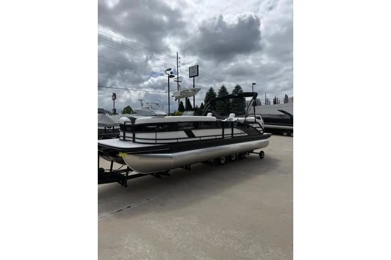 Slide: The Image of 2025 Bennington 26 MFB-SPT pontoon boat on trailer under cloudy sky. - 8