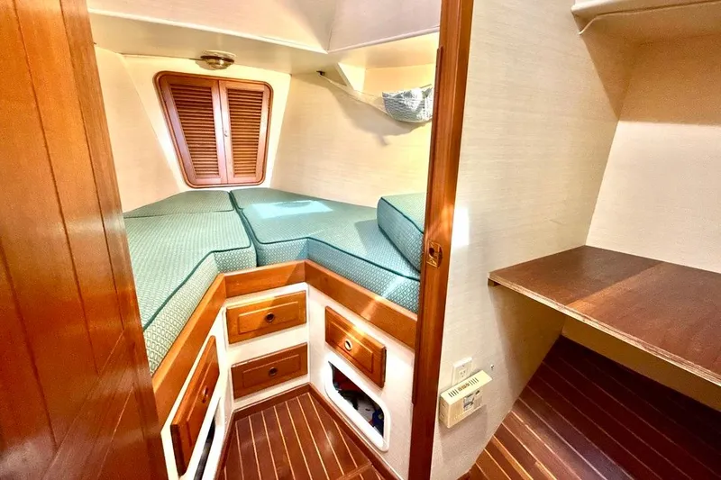 Slide: The Image of Cozy cabin interior of 1985 MetalCraft 44 boat with wooden accents and cushioned bed. - 13