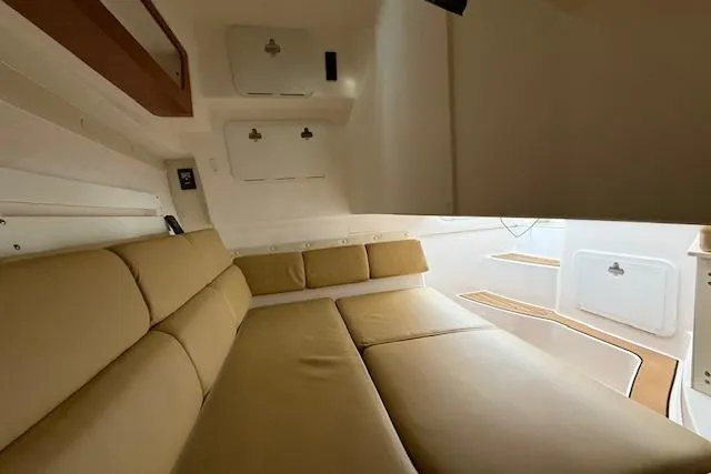 Slide: The Image of Interior of 2015 Edgewater 280CX Crossover boat with beige seating and storage compartments. - 16