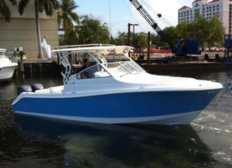 Slide: The Image of Manufacturer Provided Image: 2015 Edgewater 280CX Crossover boat in marina, featuring sleek blue and white design. - 2