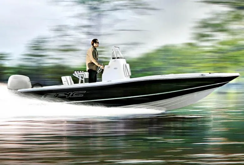 The Image of 2015 Epic 22 Sport Console boat on water near a bridge and marina. - 0