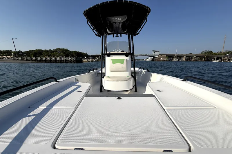 Slide: The Image of 2015 Epic 22 Sport Console boat on water, featuring spacious deck and T-top canopy. - 11