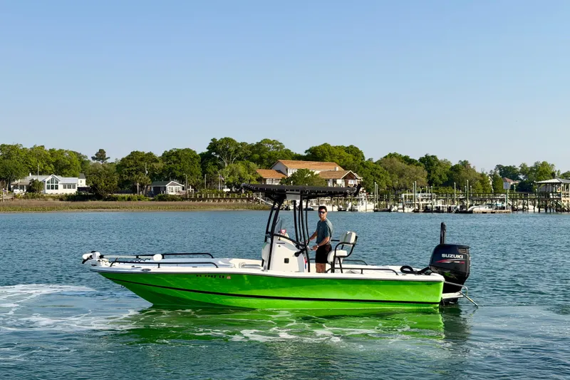 Slide: The Image of 2015 Epic 22 Sport Console boat cruising on a scenic waterway. - 2