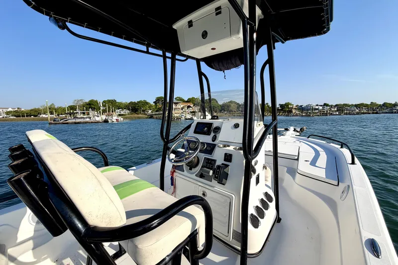 Slide: The Image of 2015 Epic 22 Sport Console boat on water, featuring steering console and seating. - 9