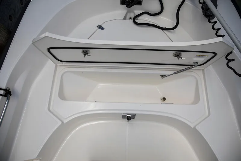 Slide: The Image of Manufacturer Provided Image: 2026 Boston Whaler 170 Montauk boat storage compartment, open lid, white interior. - 13