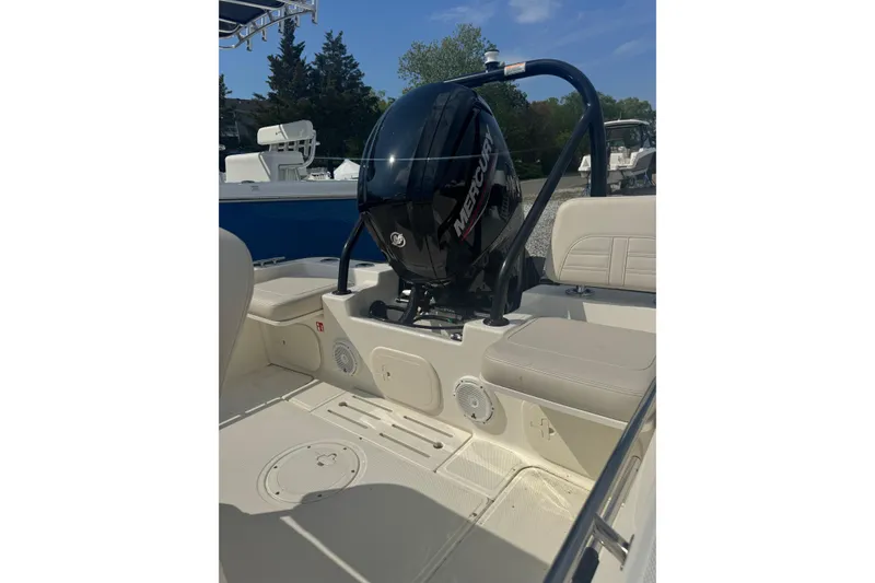 Slide: The Image of 2026 Boston Whaler 170 Montauk boat interior with Mercury engine, beige seating, and storage compartments. - 35