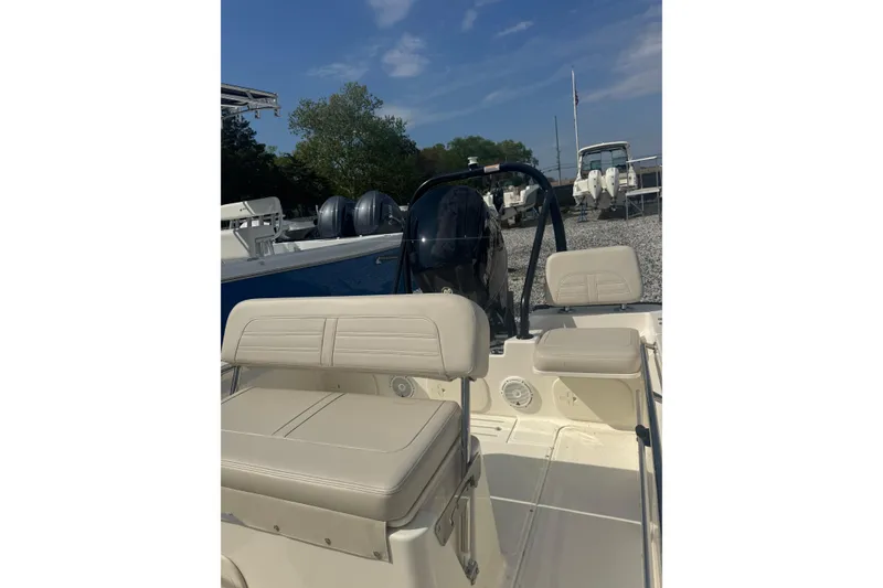 Slide: The Image of 2026 Boston Whaler 170 Montauk boat interior with seating and console, parked outdoors. - 36