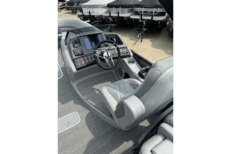 Slide: The Image of 2025 Bennington 27 QXFBAT2 boat helm with modern controls and luxurious seating. - 11