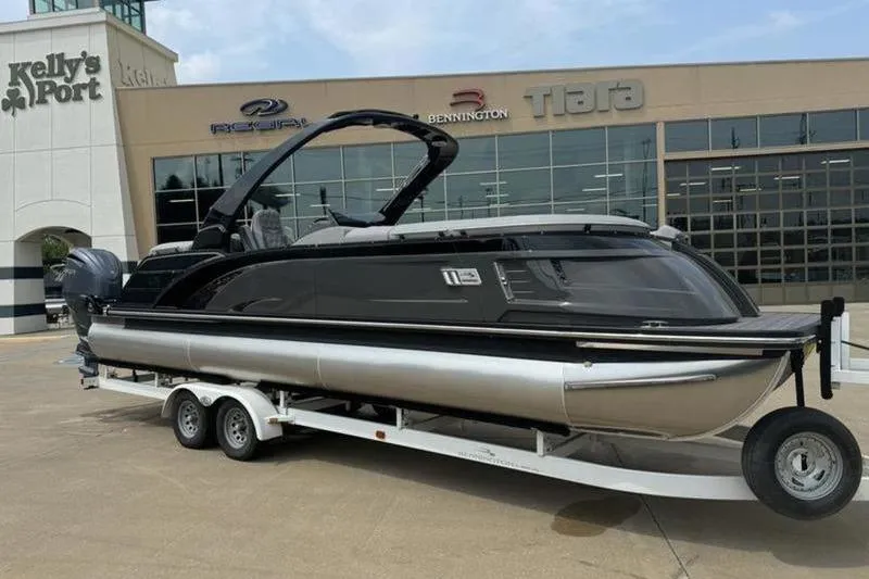 Slide: The Image of 2025 Bennington 27 QXFBAT2 pontoon boat on trailer outside dealership. - 3