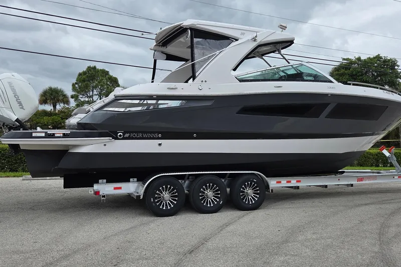 The Image of 2019 Four Winns H350 OB boat on trailer, sleek design, parked outdoors. - 0