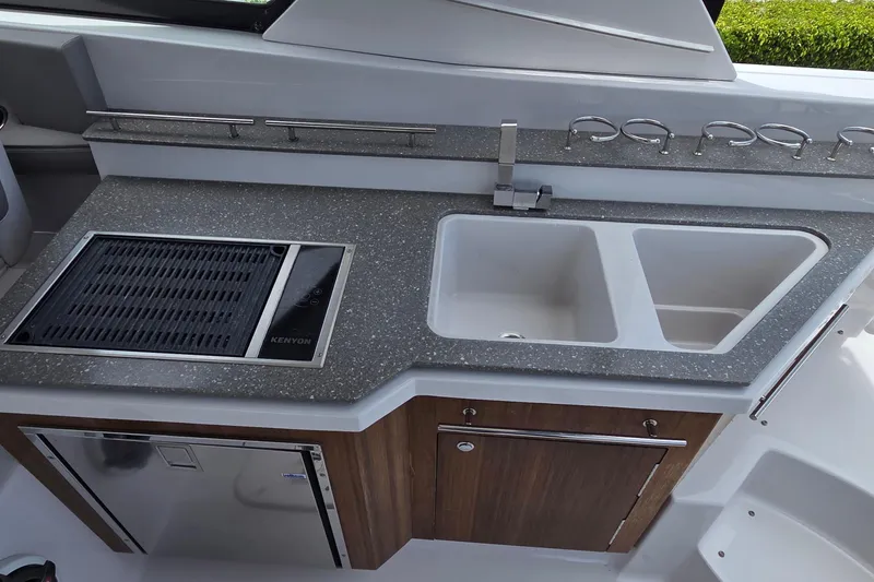 Slide: The Image of 2019 Four Winns H350 OB boat kitchen with grill, sink, and storage. - 10