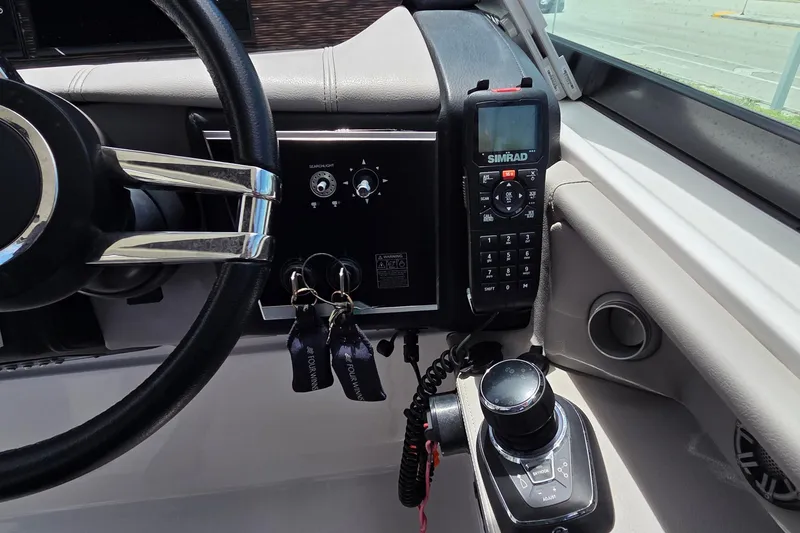 Slide: The Image of Helm of 2019 Four Winns H350 OB boat with steering wheel and Simrad marine radio. - 21