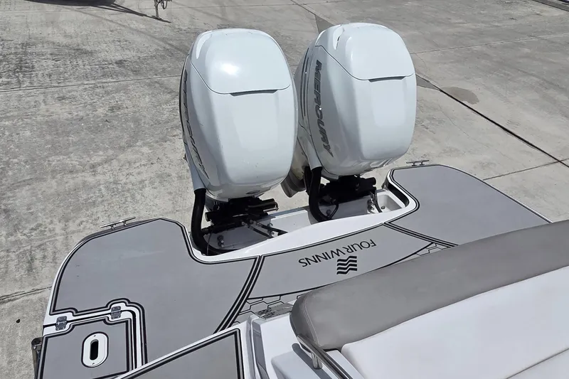 Slide: The Image of 2019 Four Winns H350 OB boat with dual Mercury outboard engines on a concrete surface. - 25